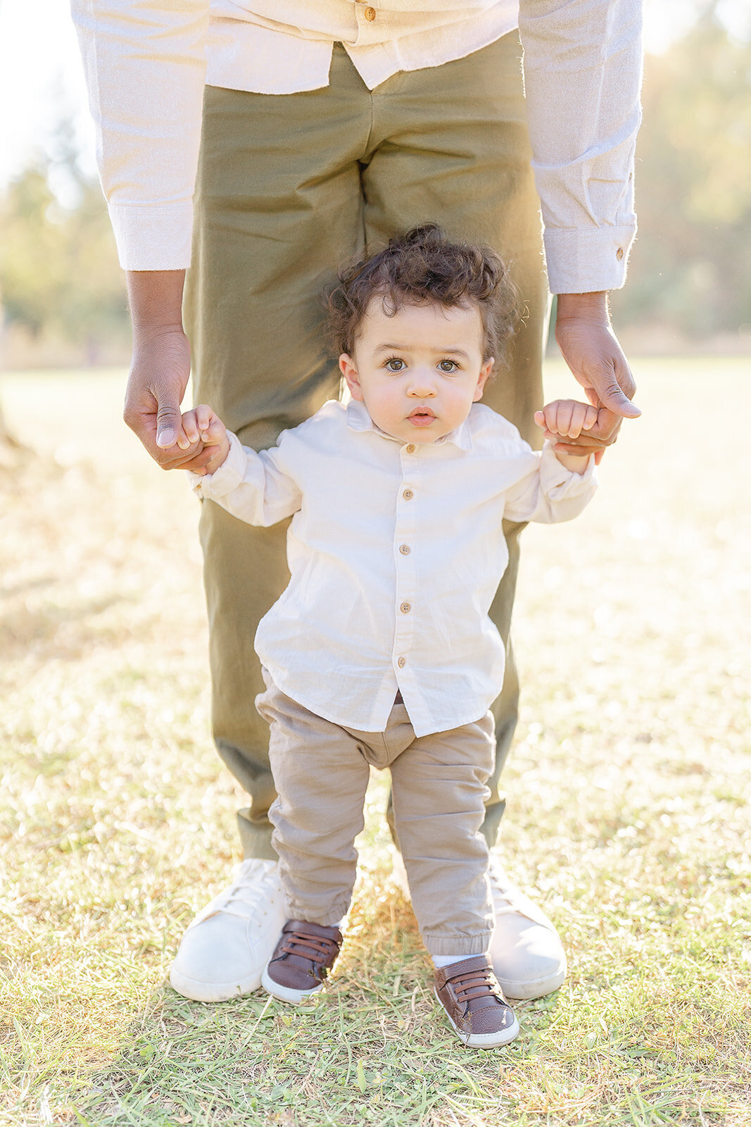 toddler holding dad’s hand during fall mini session in Alexandria, VA