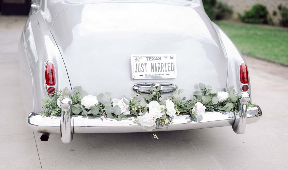 photo of car bumper with just married license plate and floral  accents