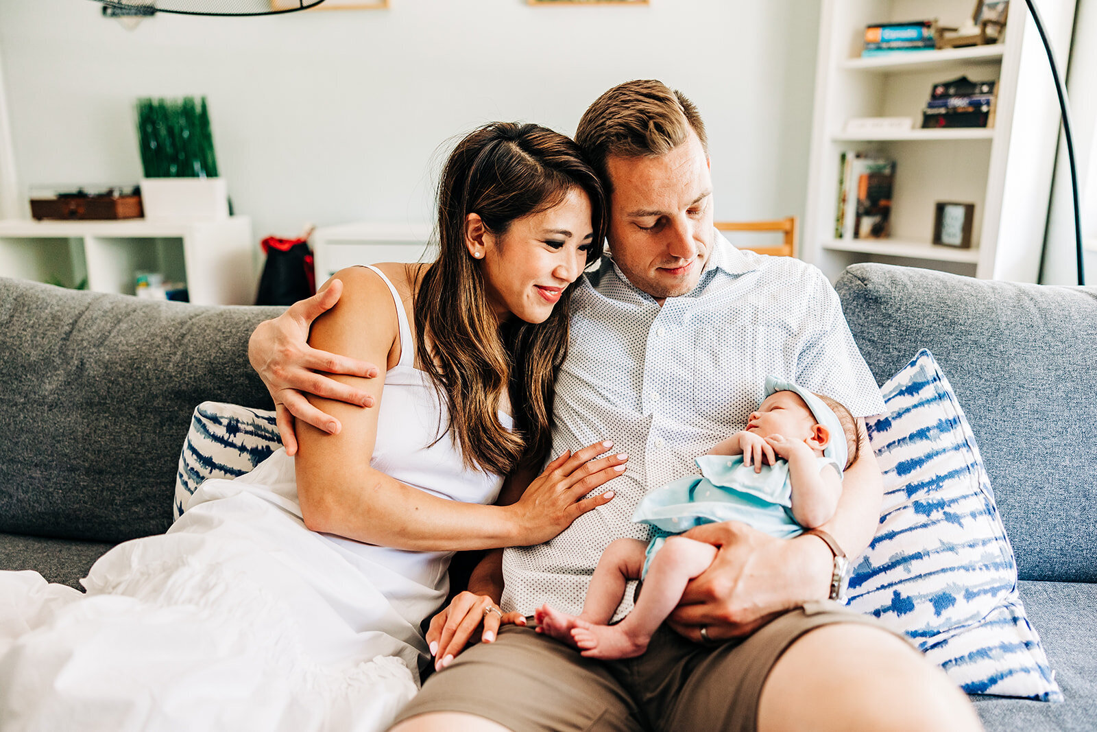 Mother and Father sitting adoring thier new baby in a home in st. pete fl