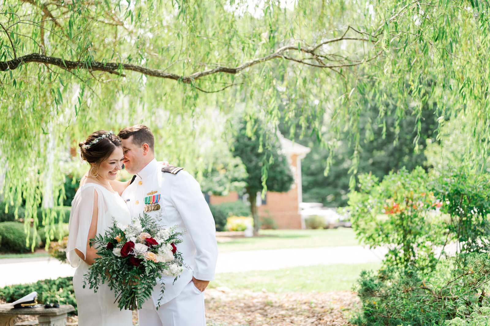 Wedding photography portrait of couple in white dress and white Marine formal apparel posing under a willow tree in Augusta County Virginia.