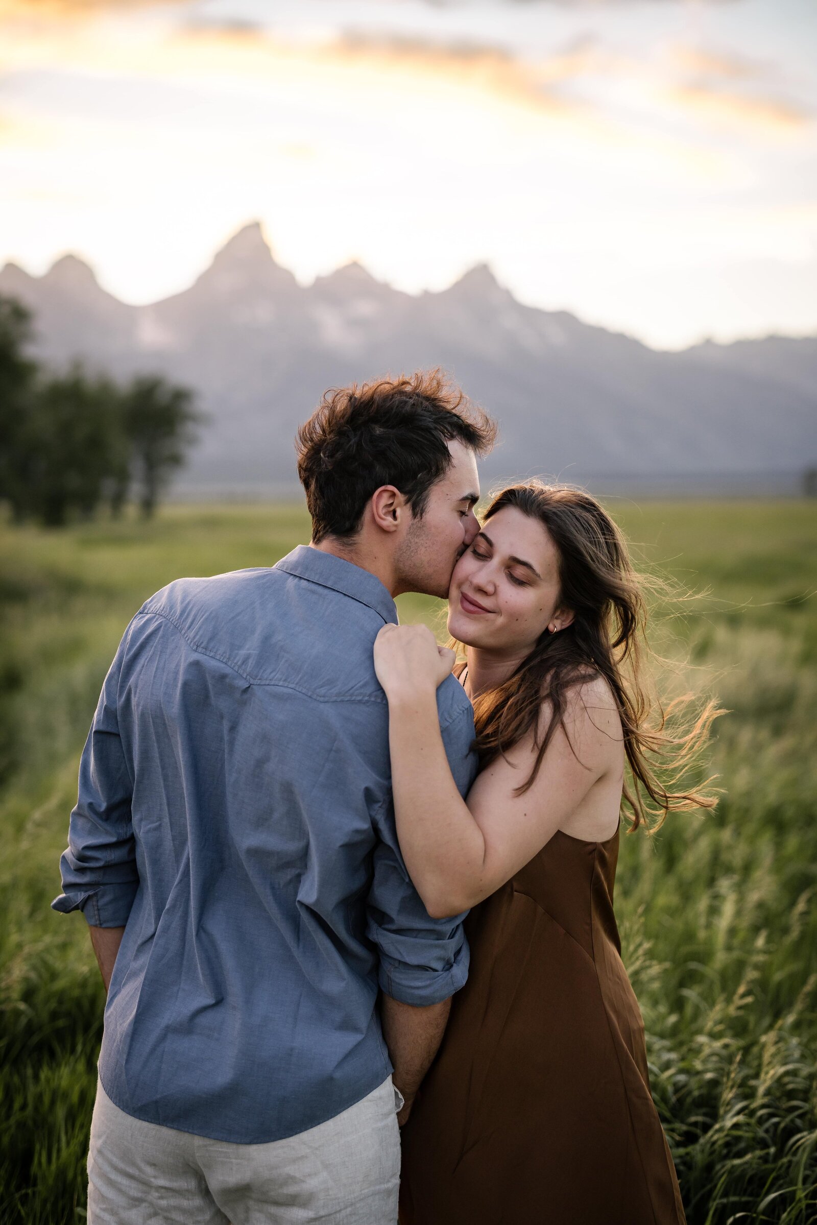 couple kissing with the Tetons in the background