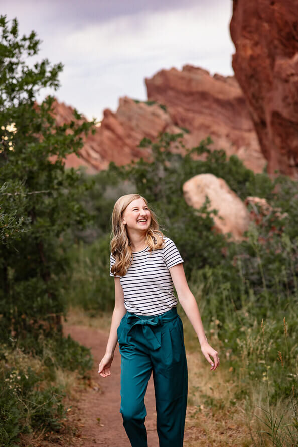 Girl smiles and walks through Roxborough Park.