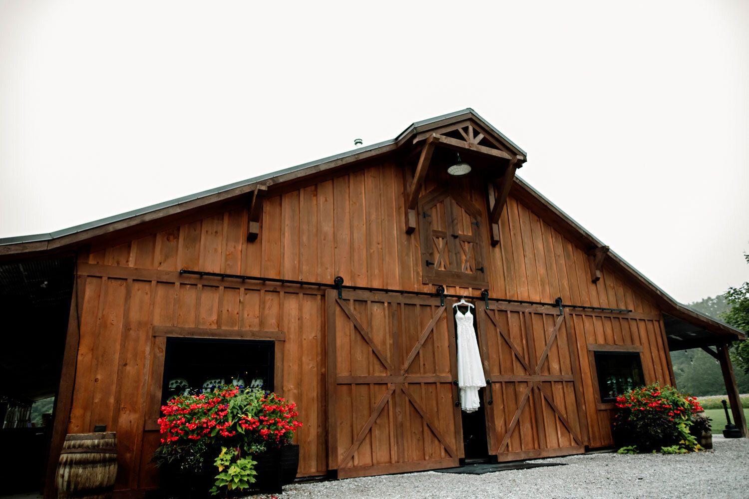 Wedding gown hanging on the wooden barn exterior