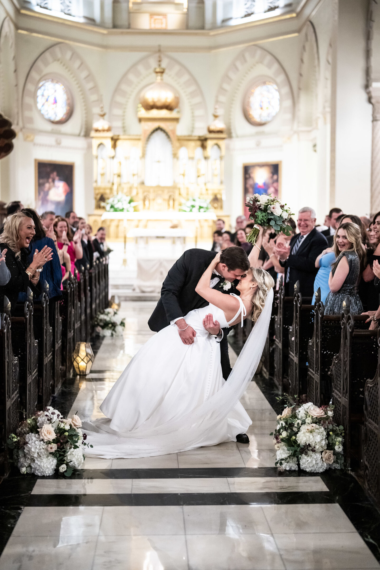 Groom dips bride at end of Immaculate Conception wedding ceremony