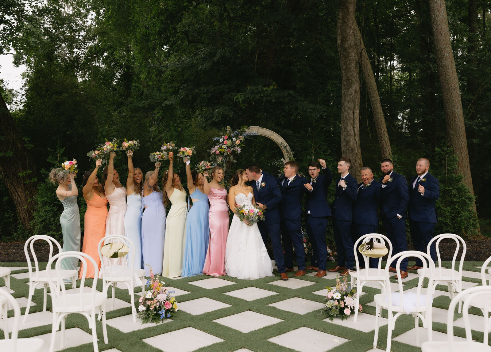 bride and groom with the wedding party at their ceremony space