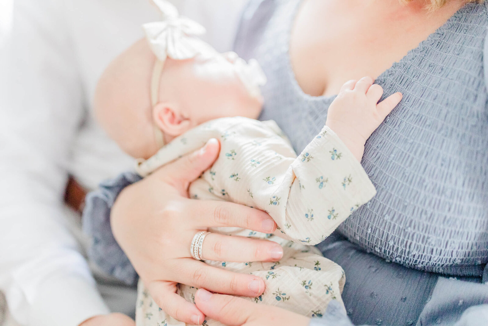 Close up of baby's hand on mom's chest while the baby sleeps