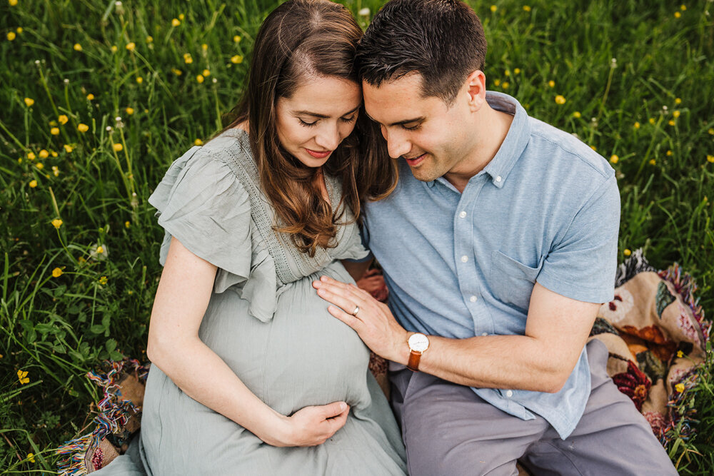 overhead picture of pregnant couple sitting together on blanket