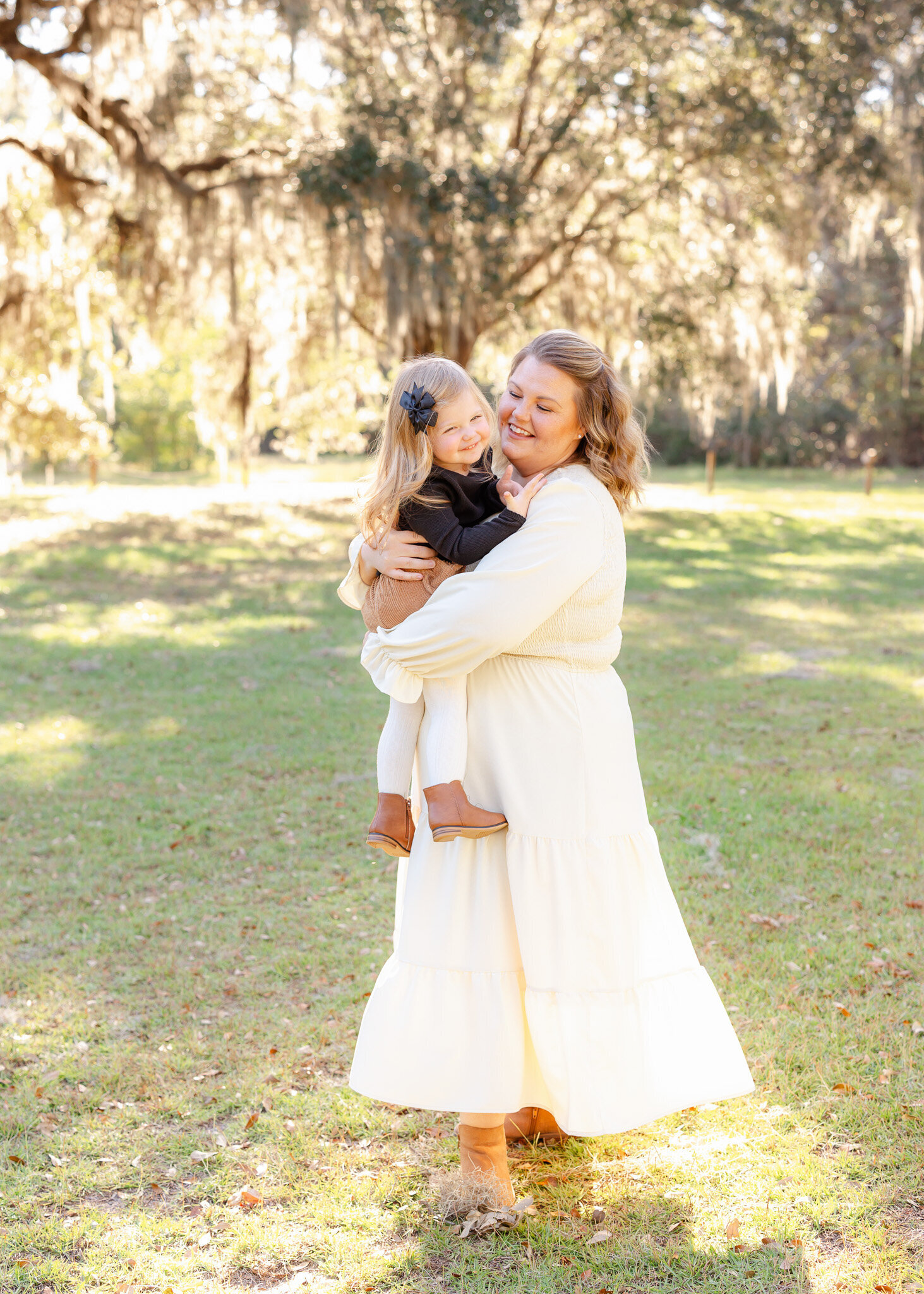 Mom holding and laughing with her daughter during her family photoshoot with Constance Calton Photography