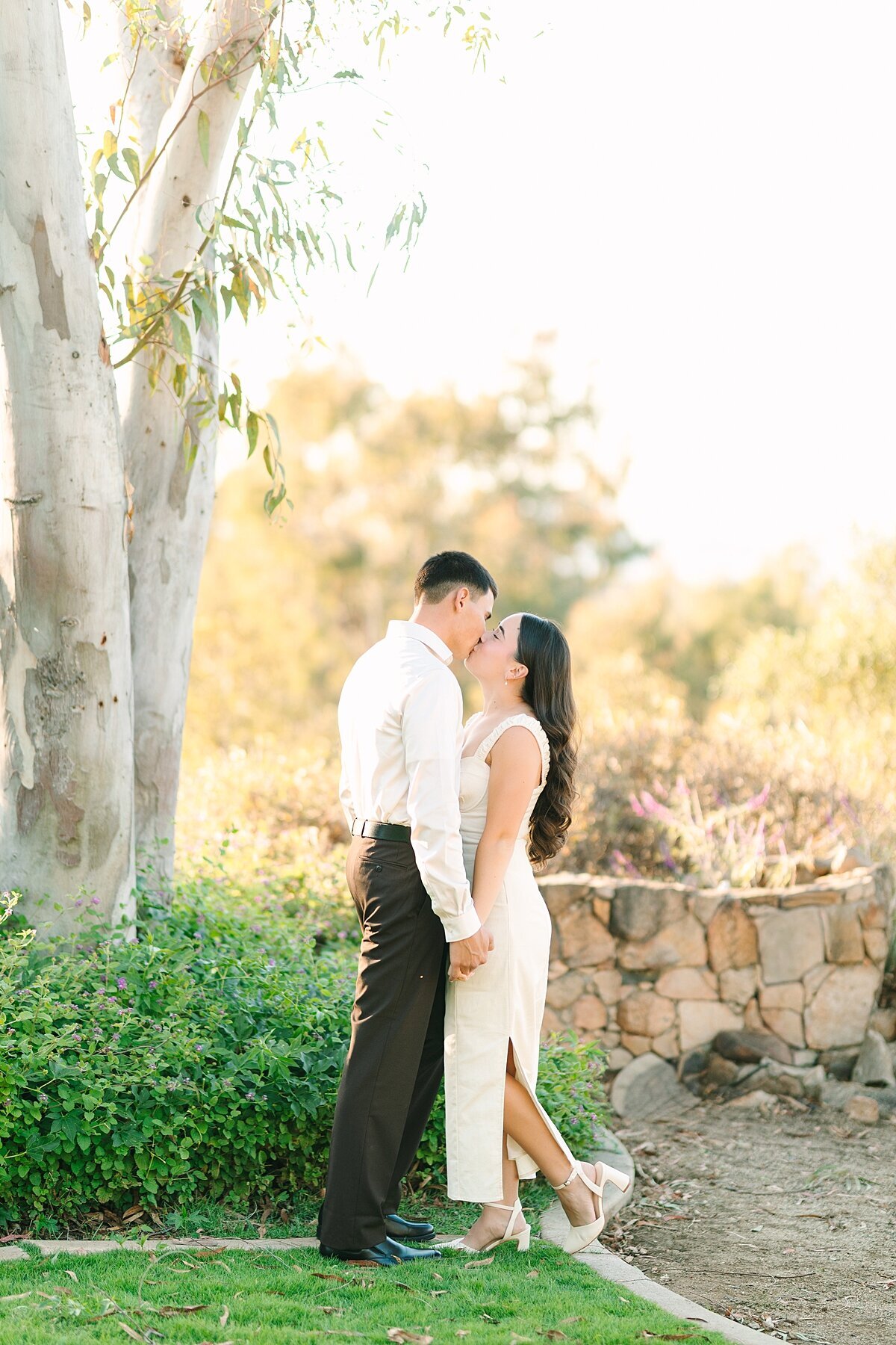 Engaged couple kissing during their engagement photoshoot at Alta Vista Botanical Gardens in Vista, CA.