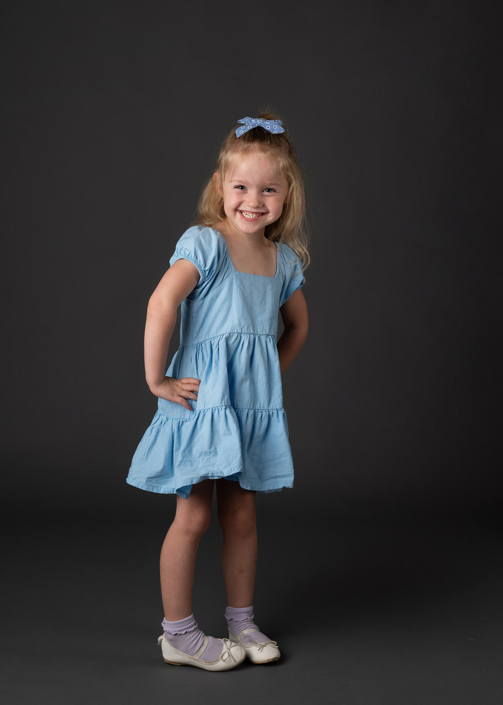 A cute young girl smiling for her school portrait session.