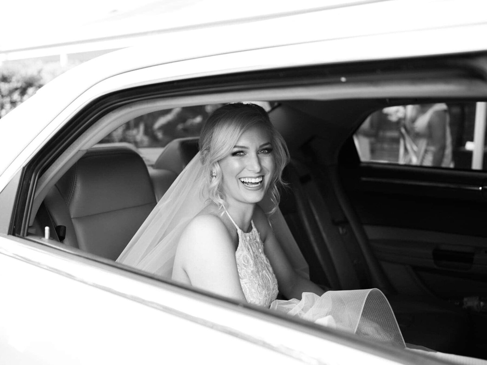 Bride smiling in the car arriving to her wedding ceremony at Austinvilla Estate