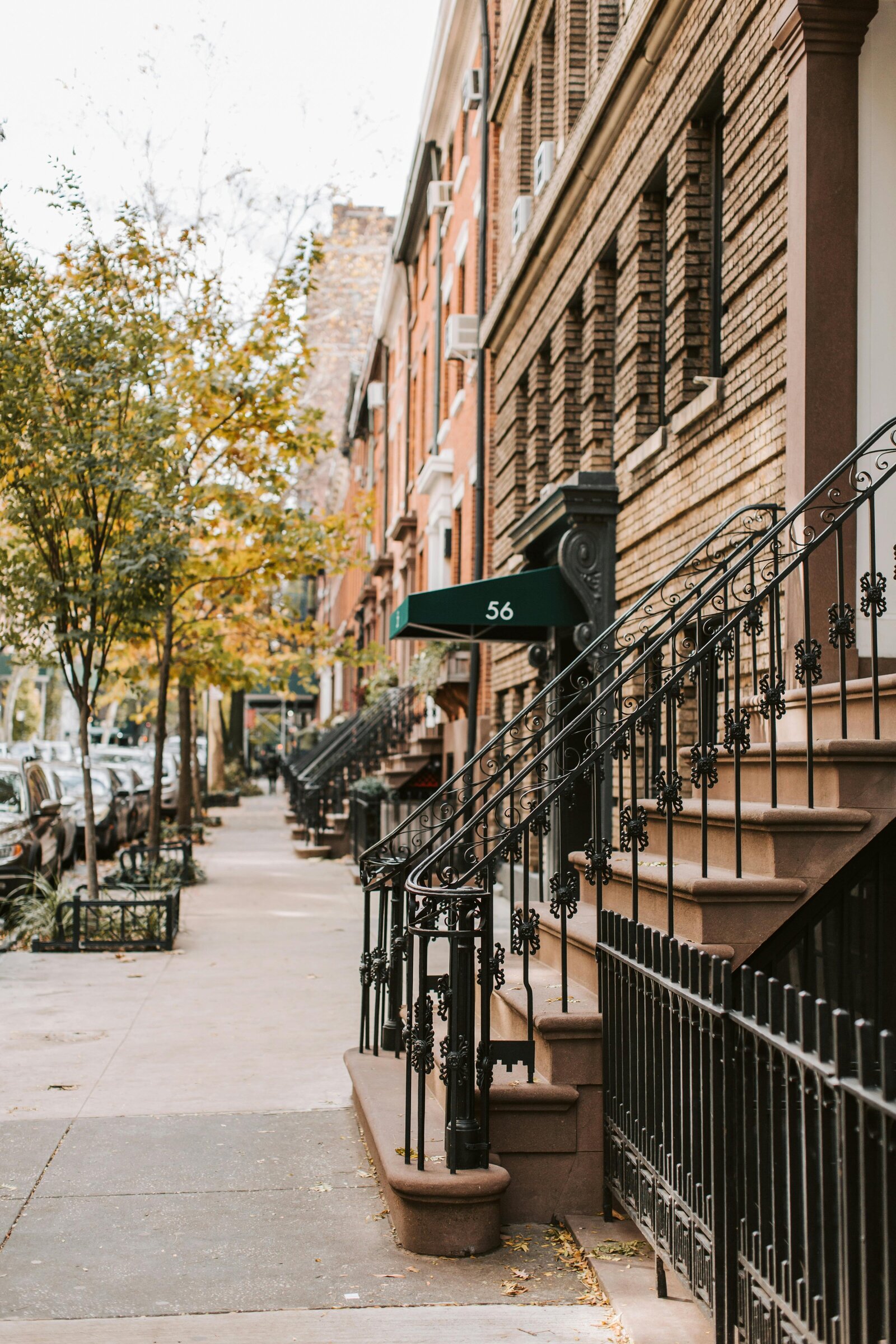 Historic townhouses with stoops and railings in the West Village, NYC.