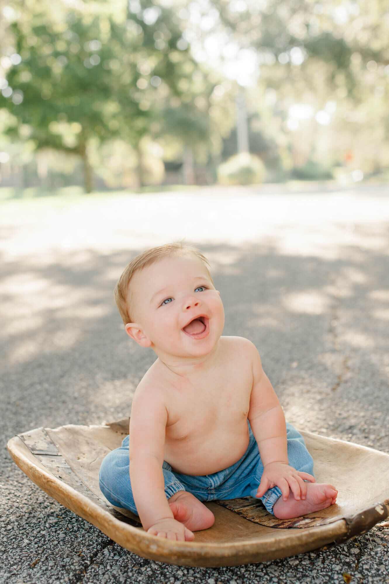 Melbourne Fl family photographer captures son smiling while sitting on a wooden seat in the middle of the road