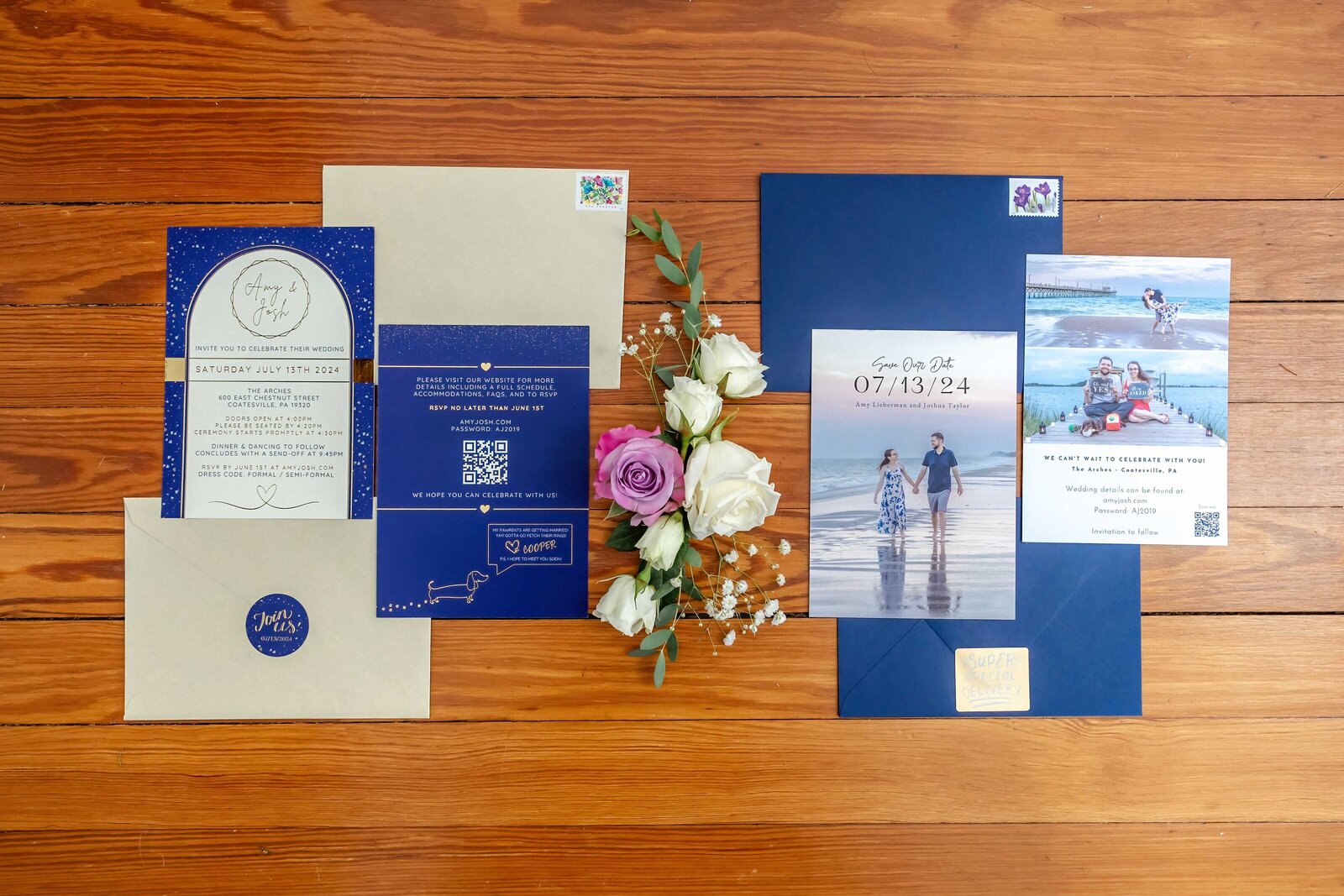 A flat lay of celestial-themed wedding invitations, RSVP cards, and envelopes displayed with white and purple roses, captured on wooden flooring during a Coastesville, PA wedding, blending elegance and personal details.