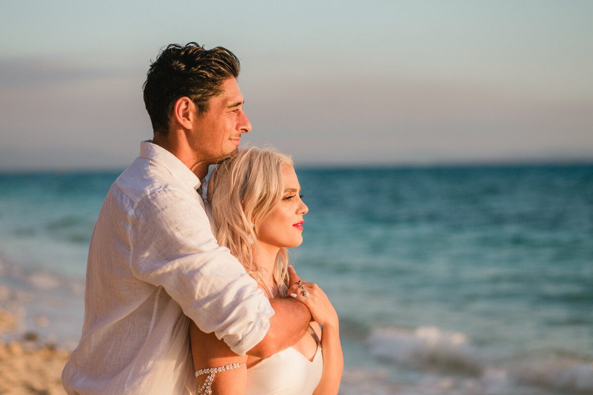 bride and groom looking out to sea