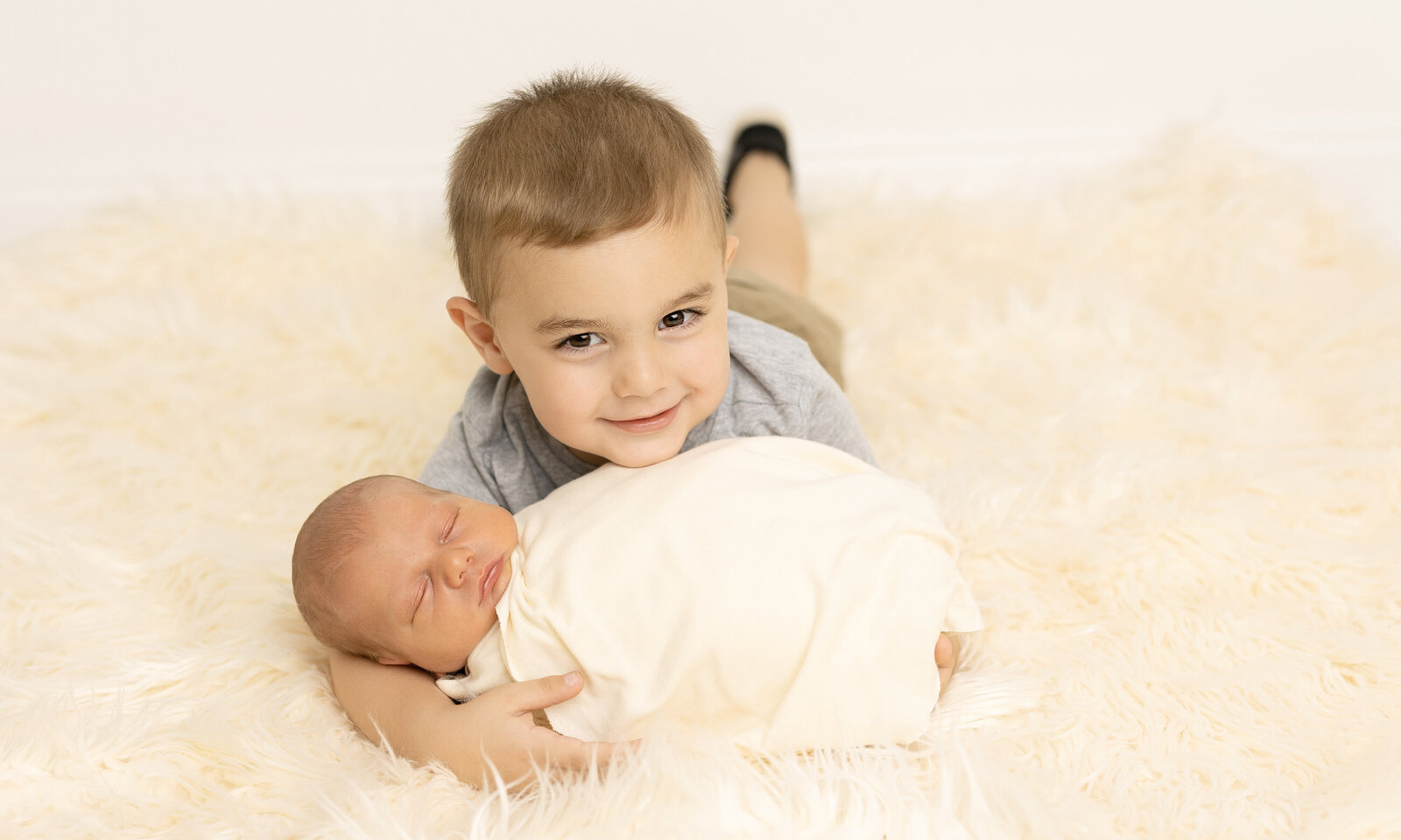 newborn baby with brother for sibling shot laying down