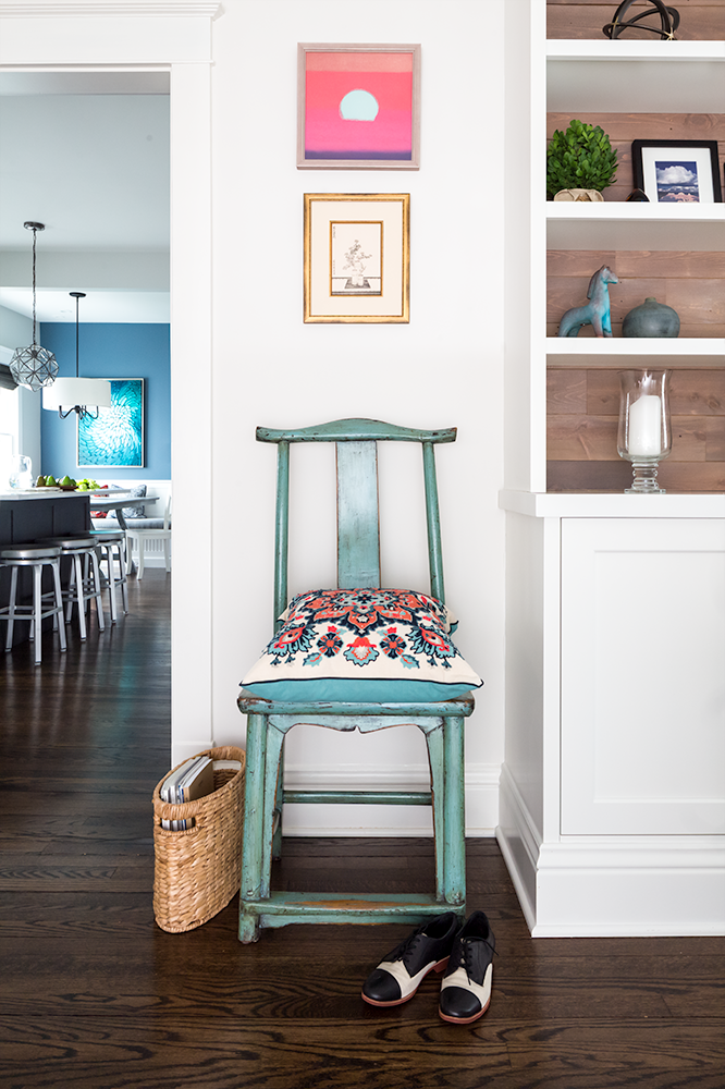 Turquoise wooden chair with colorful embroidered pillows