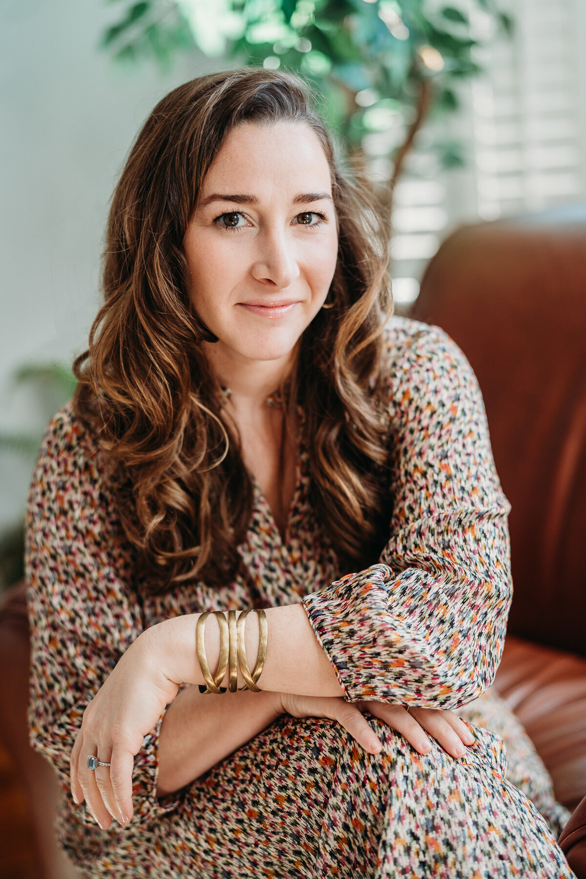 headshot of woman in a printed dress staring straight at camera for headshot