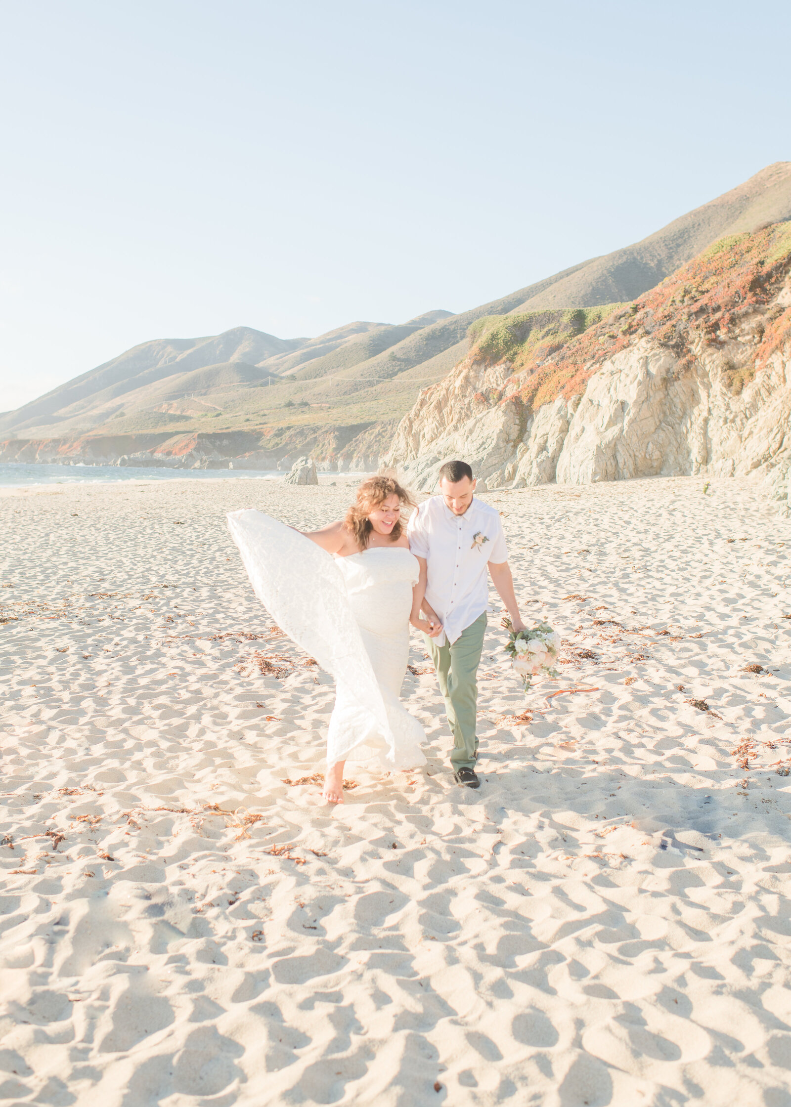 bride and groom walking down beach