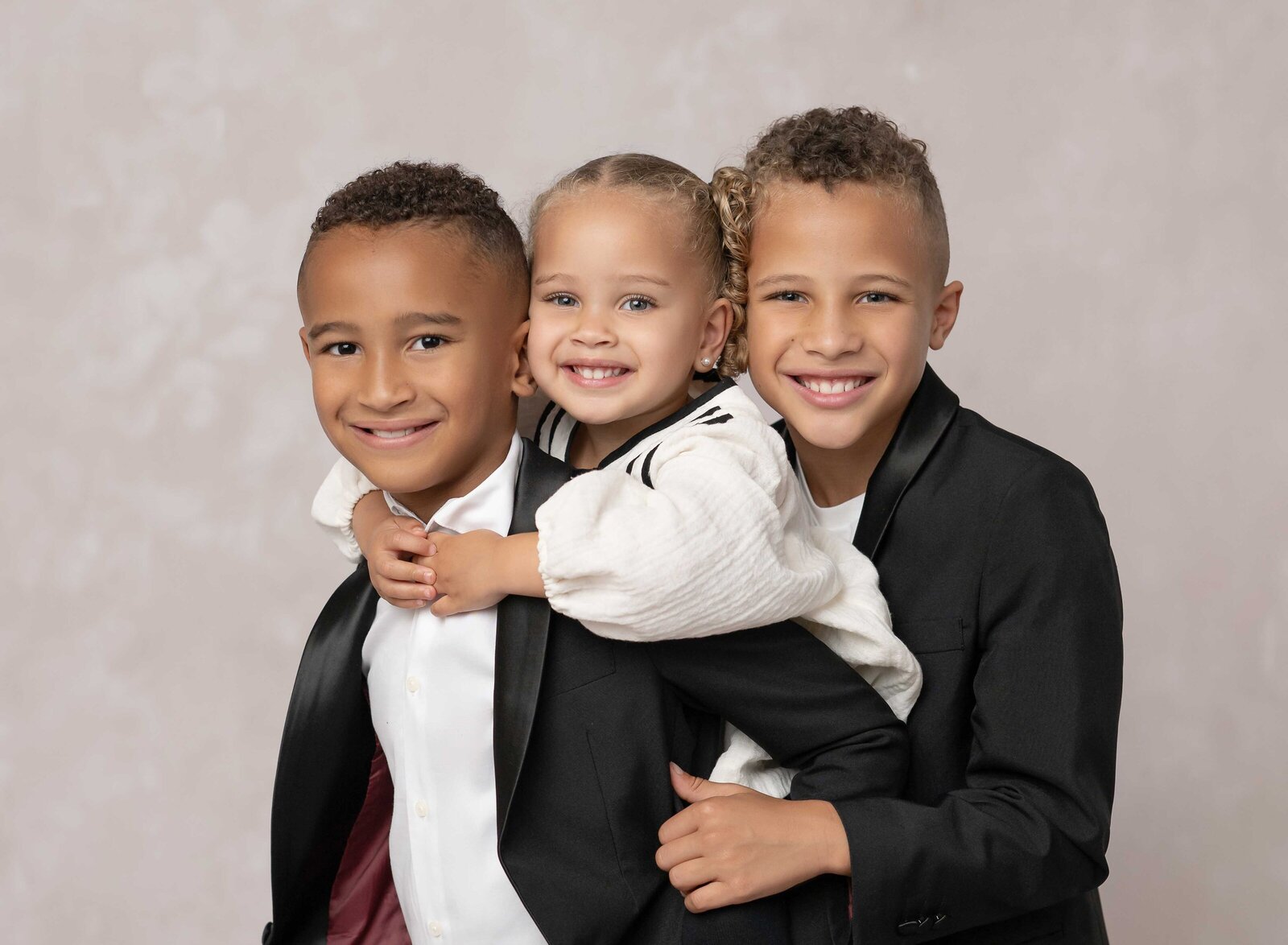 Sibling photo with sister on big brothers back. Family photo taken by Jenni Nikki Photography at Atlanta photography studio.