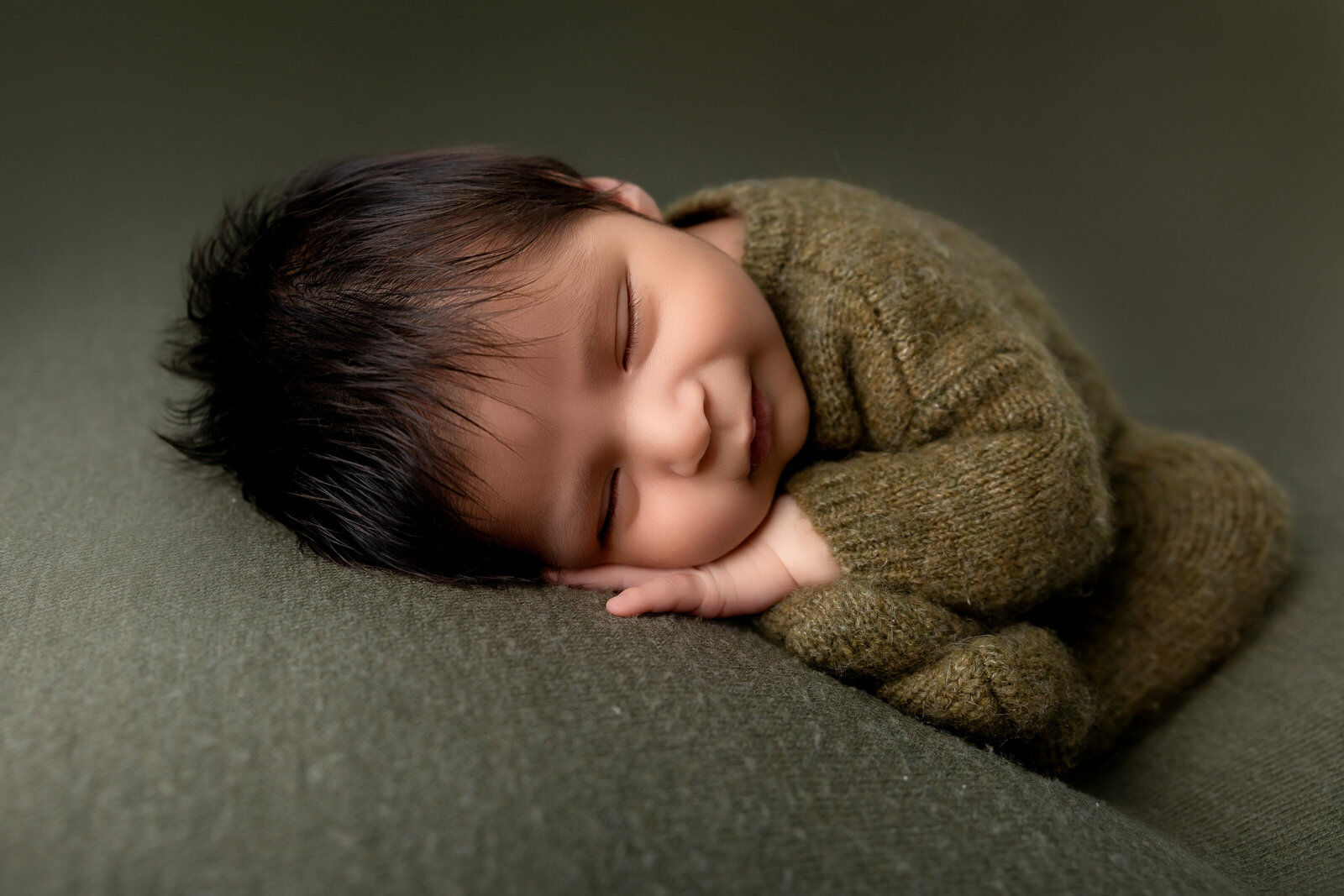 baby wearing a knitted outfit in the taco pose smiling. posed newborn photography. woodland, california