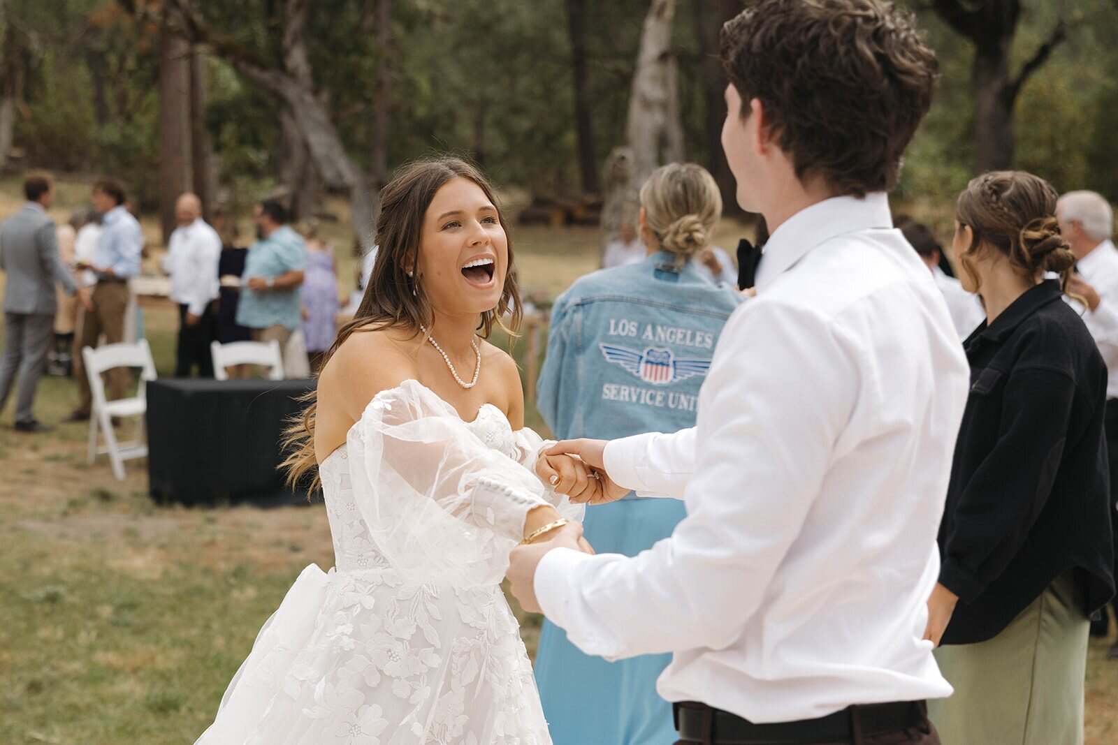Bride laughing on the dance floor with friends