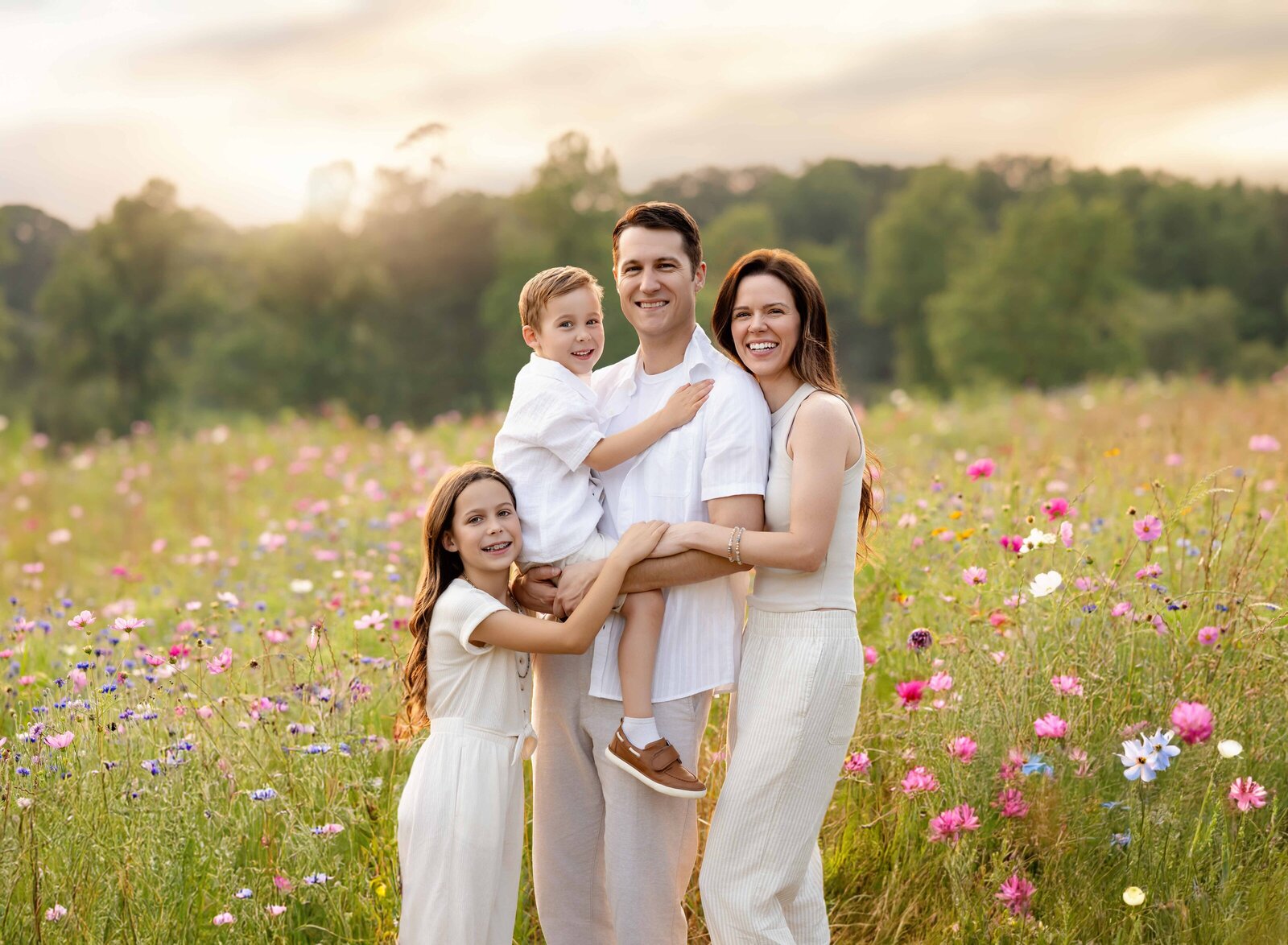 Family of 4 standing in wildflower field and smiling at camera. Wildflower field was at Prospect farms in Lawrenceville, GA- close to Atlanta.