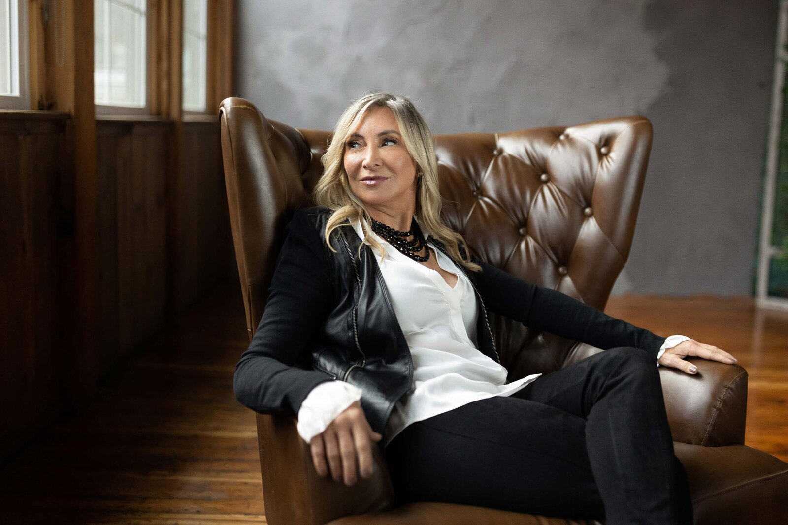 woman in a black suite sitting on a couch