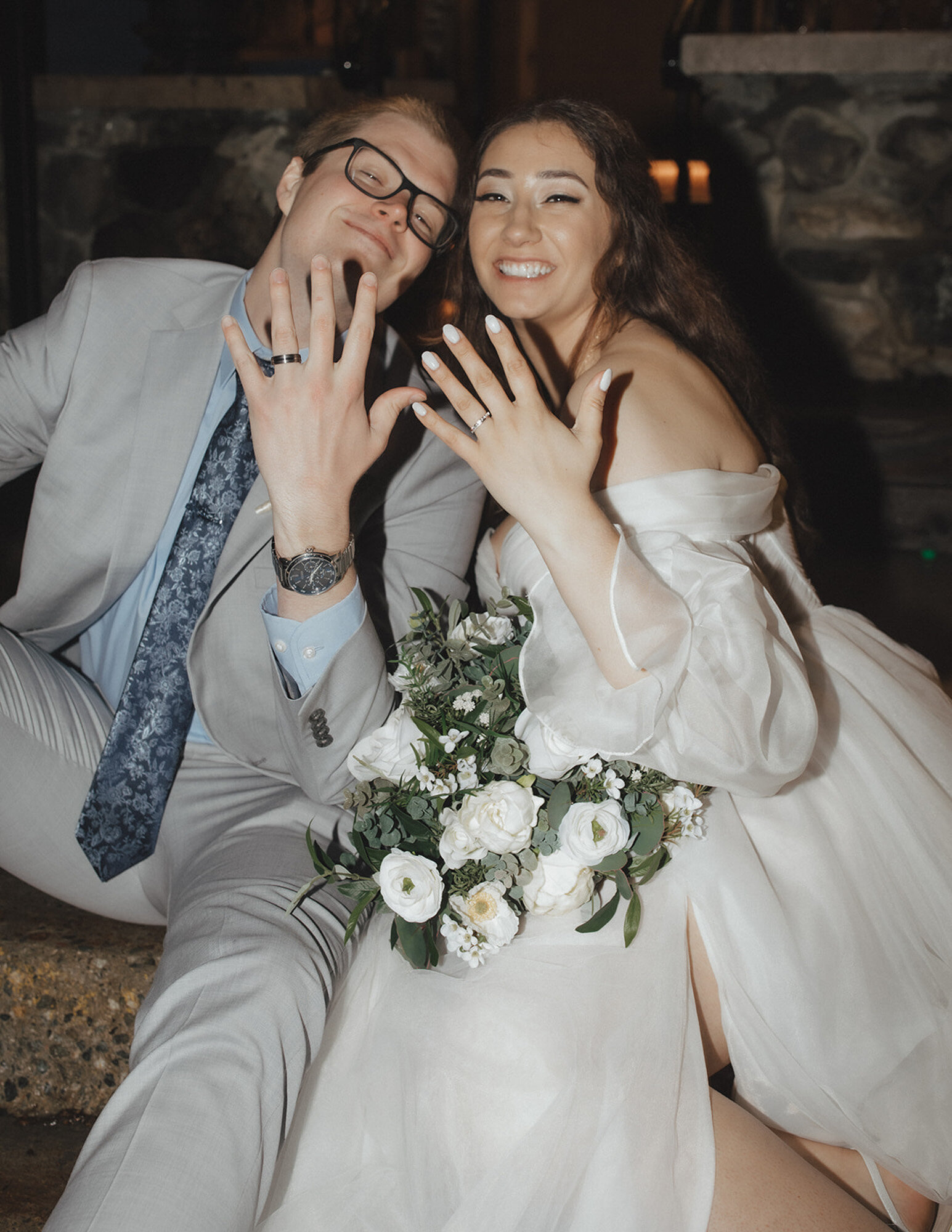 Bride and groom happily showing their hands wearing their wedding ring