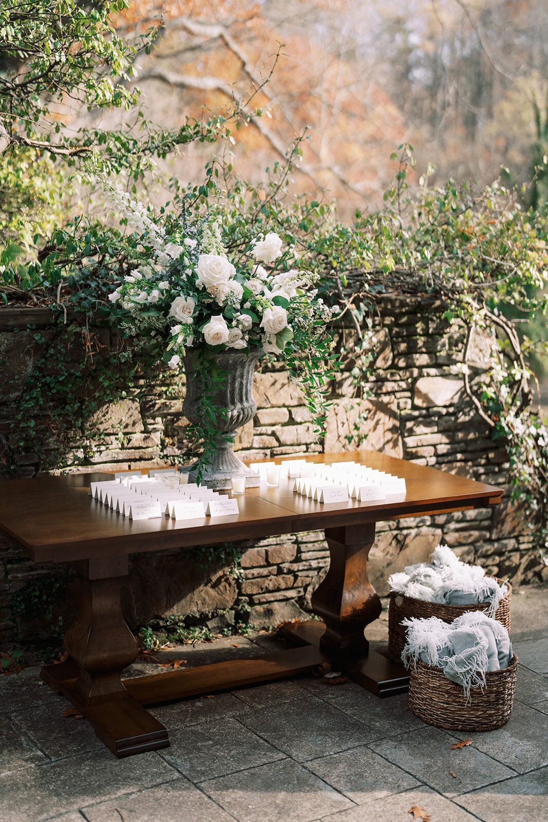 Dark wood table with place cards and lush flowers at wedding reception