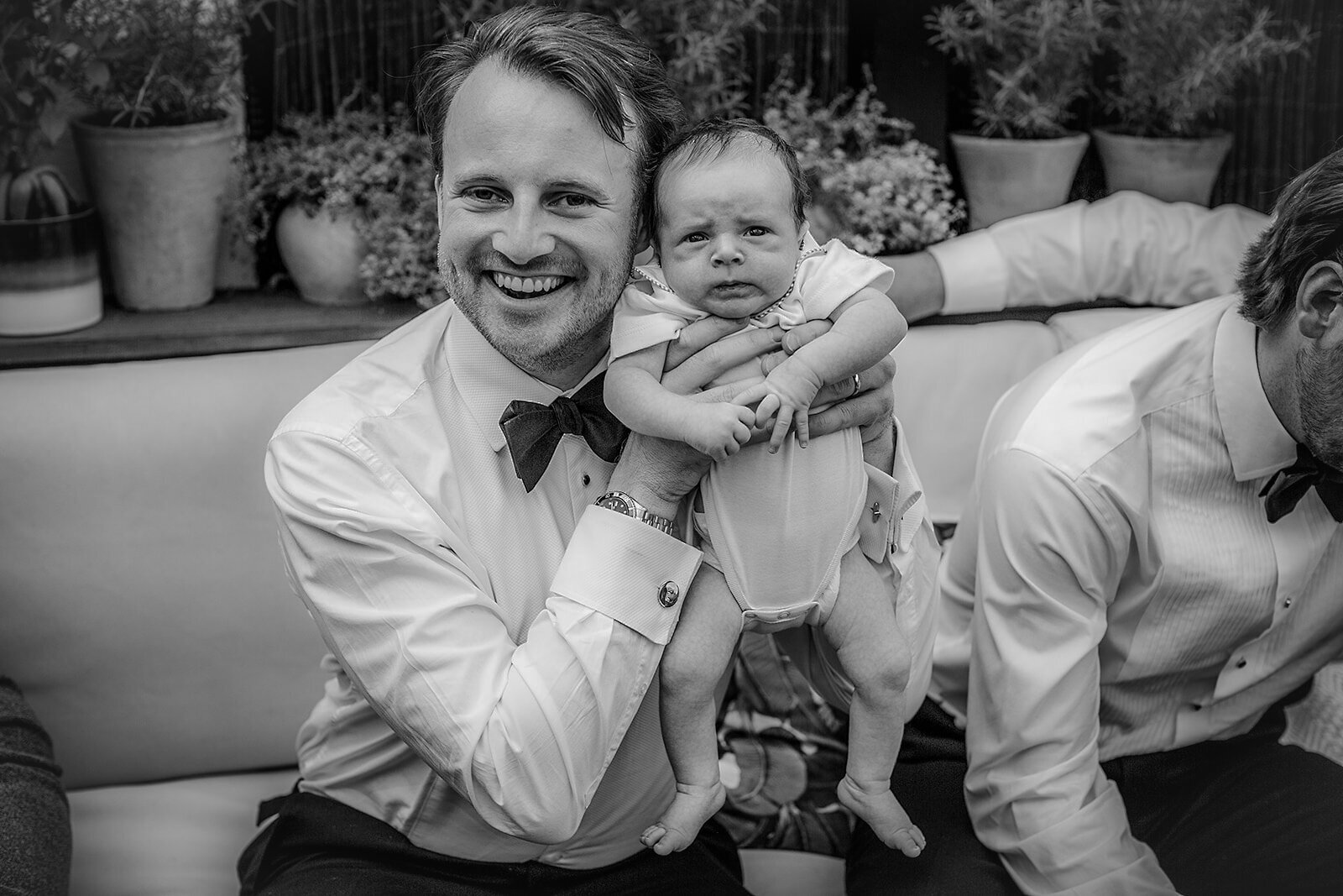 Editorial portrait of groom holding baby