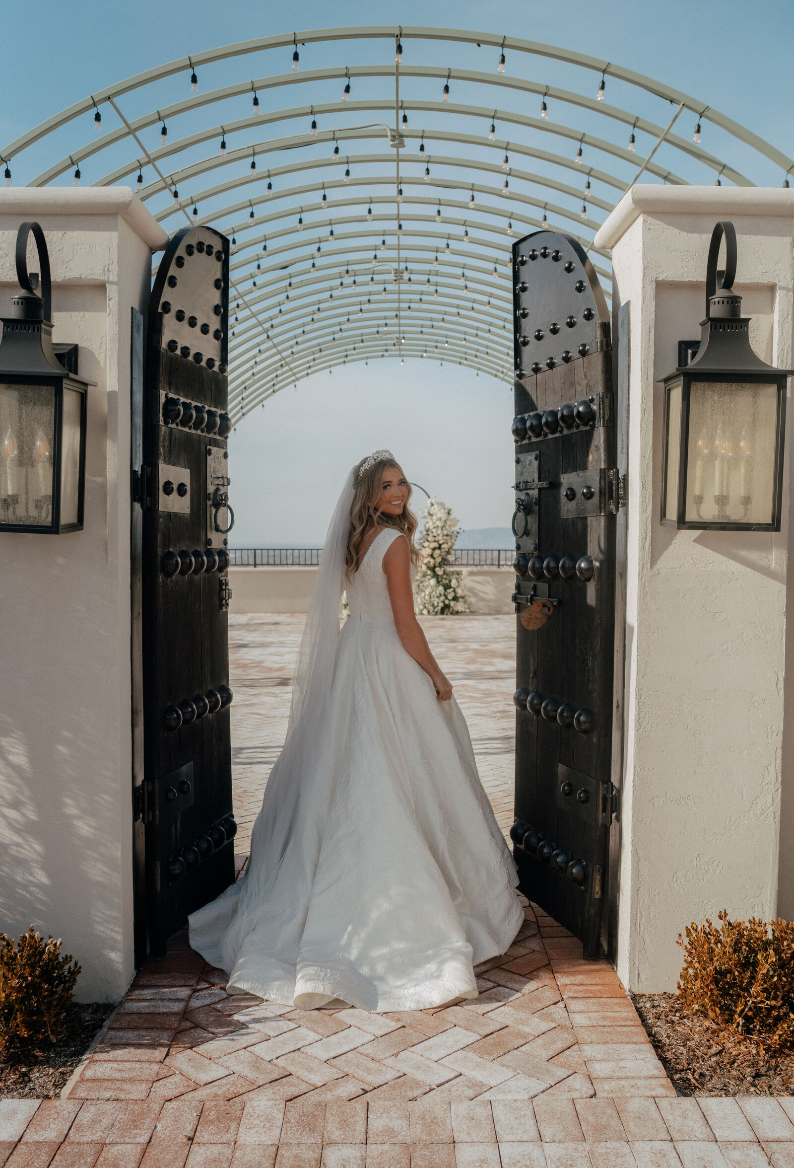 Bride in front of ceremony gate