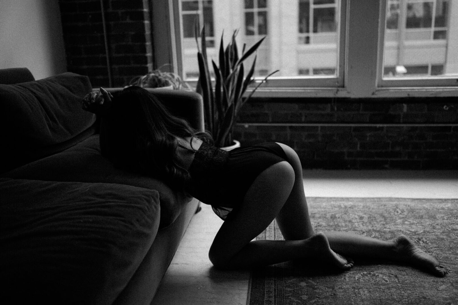 woman kneeling next to couch in seattle boudoir studio
