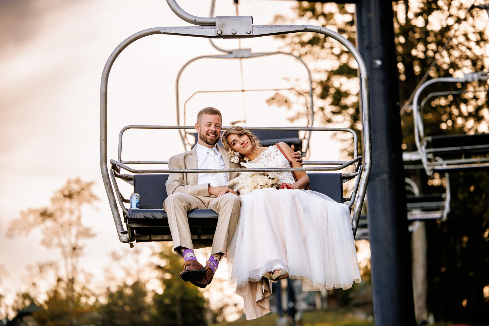 Bride and groom snuggled up on the chair lift at Peek"n Peak Resort