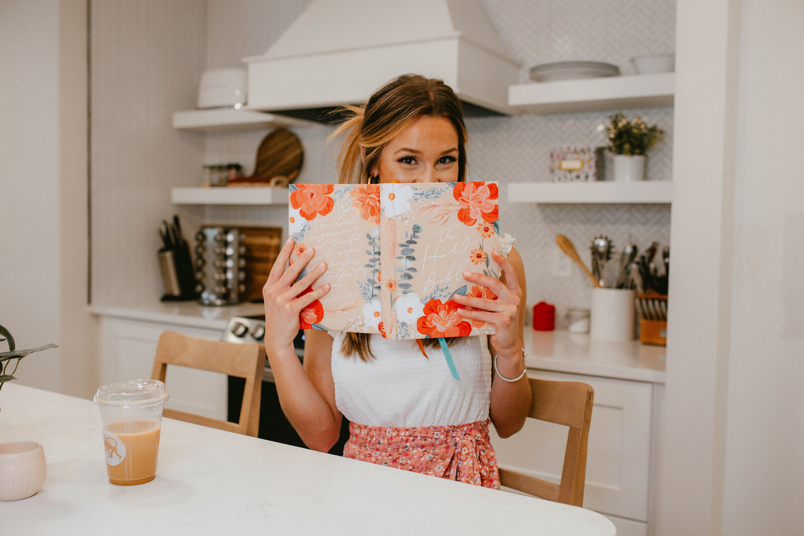 woman holding bible in cute white kitchen