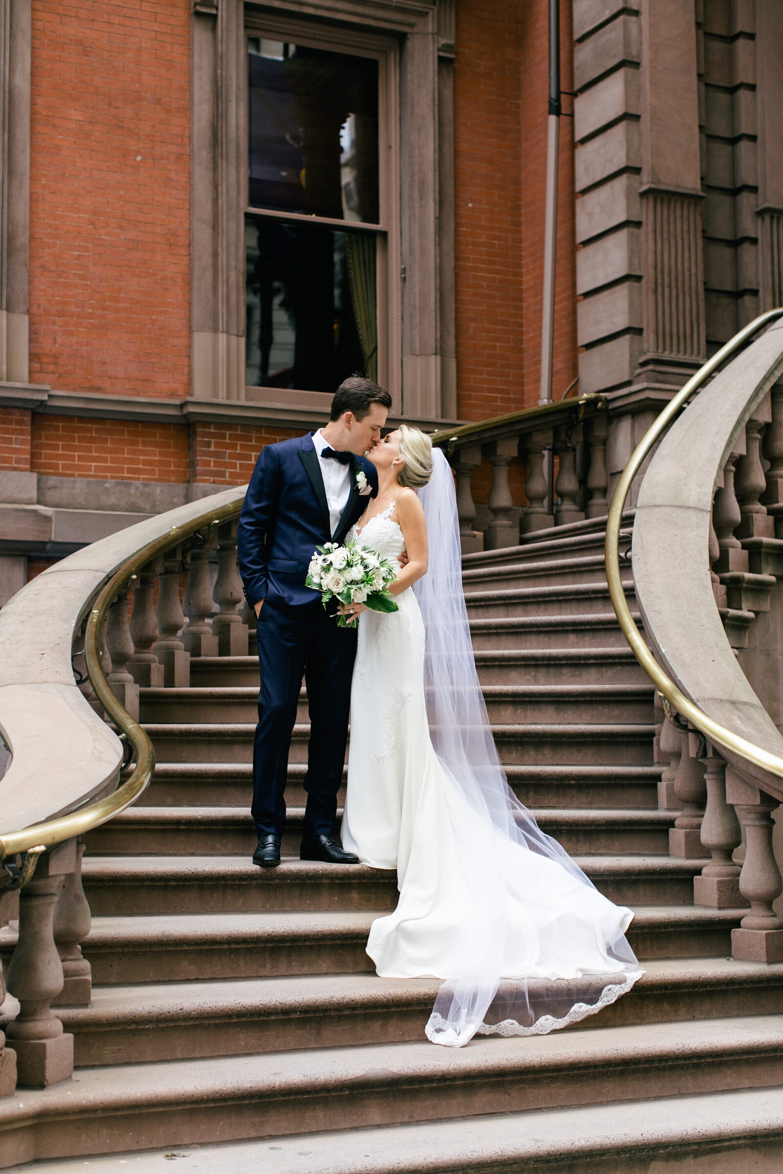 bride and groom kissing on union league stairs