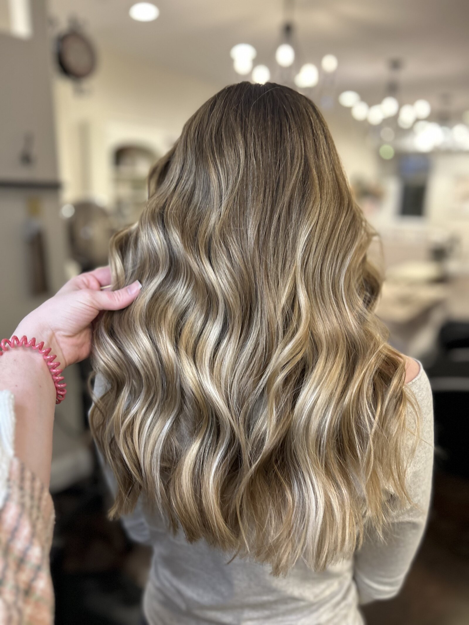 Dimensional brunette with soft waves—representing custom color and lived-in looks at Maven + Grace.”