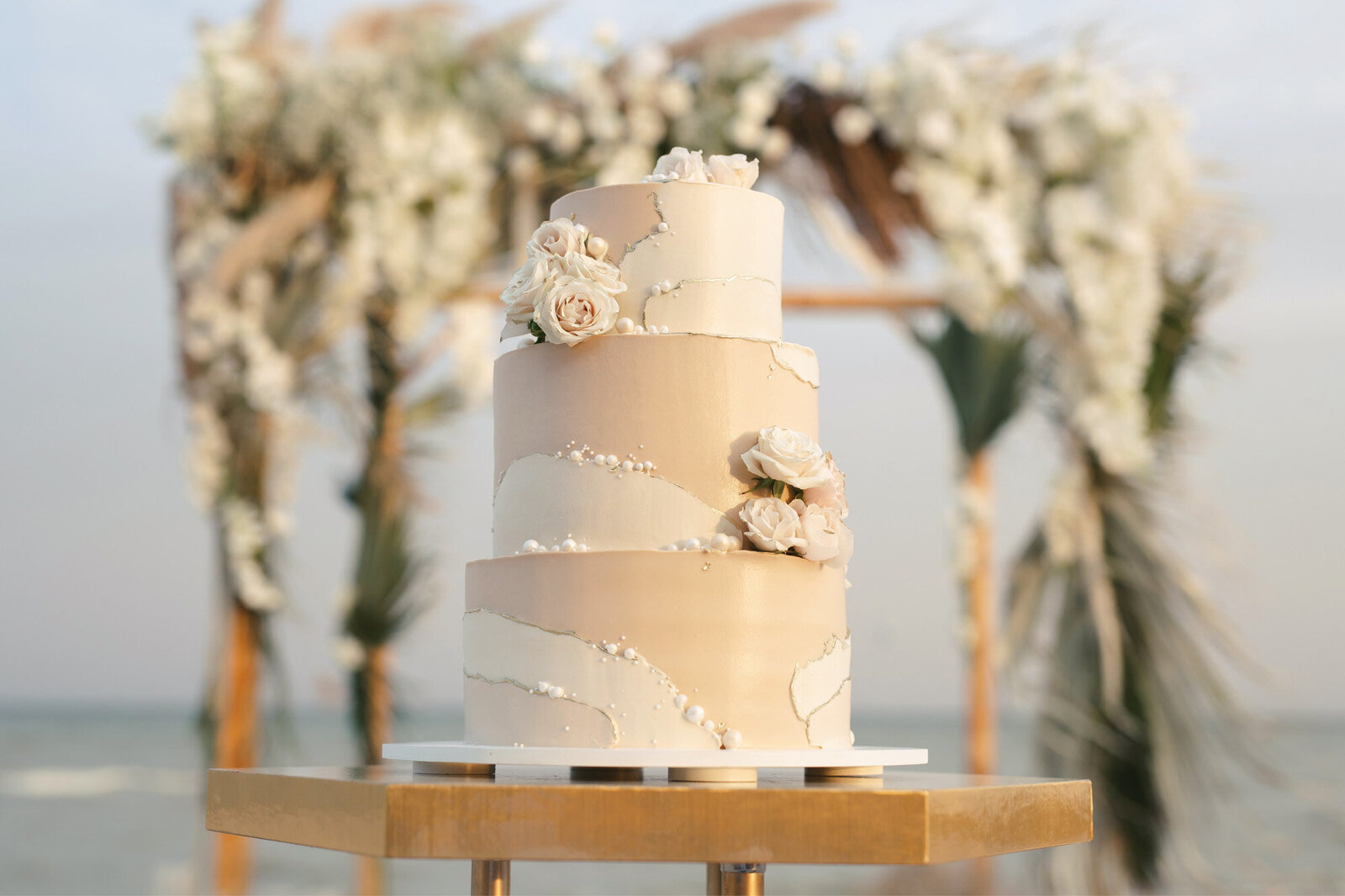 Elegant three tier wedding cake with an ocean view behind