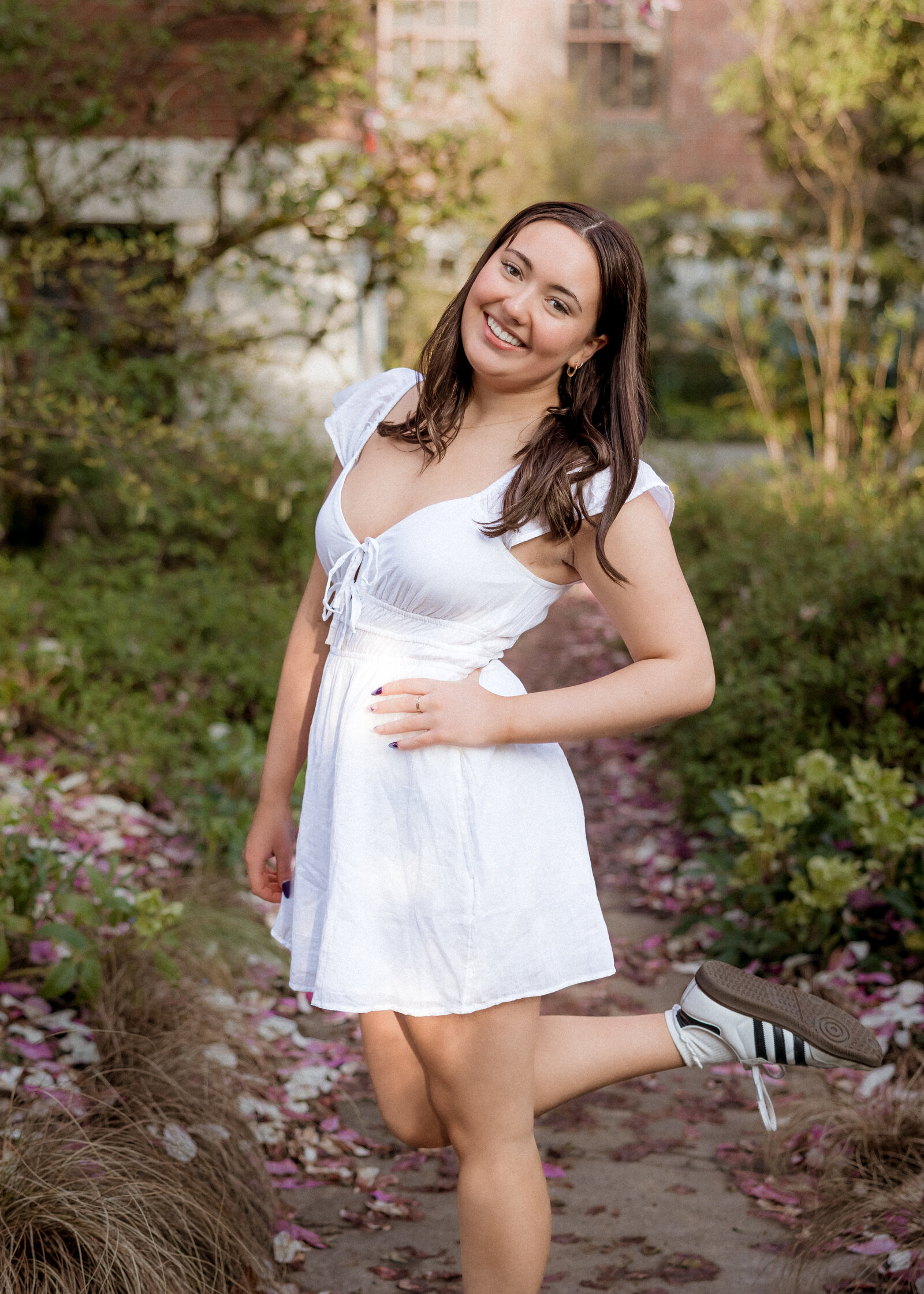 Girl posing in white dress next to magnolia tree at mcmenamins edgefield