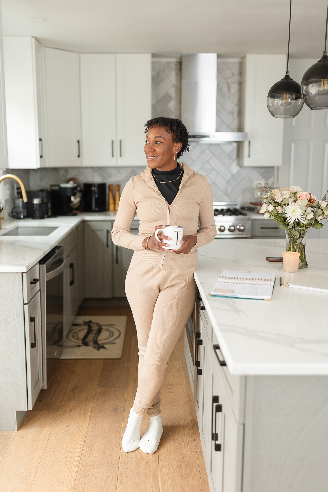 a woman sips her coffee in the kitchen