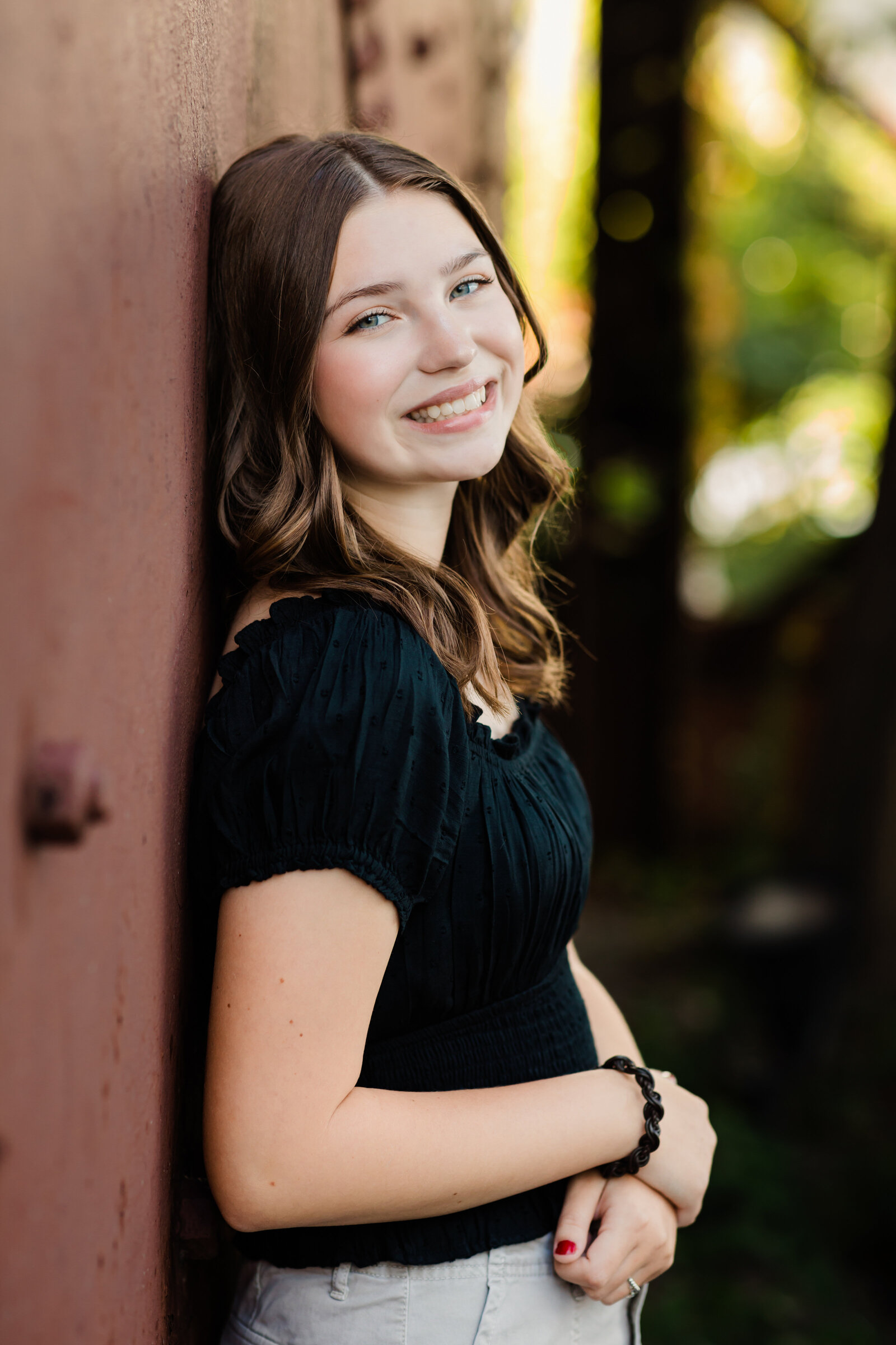 high school senior girl in black shirt posed for senior portraits at shooters on the water cleveland senior photographer