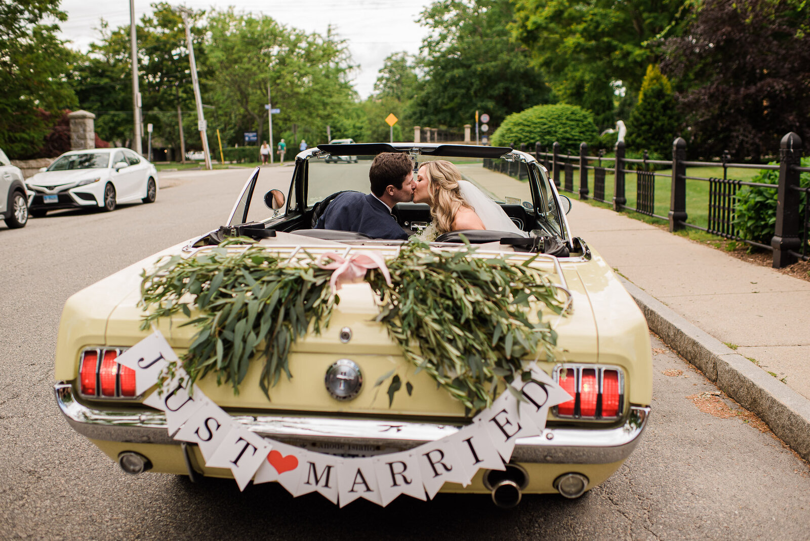 couple kiss in car with just married sign