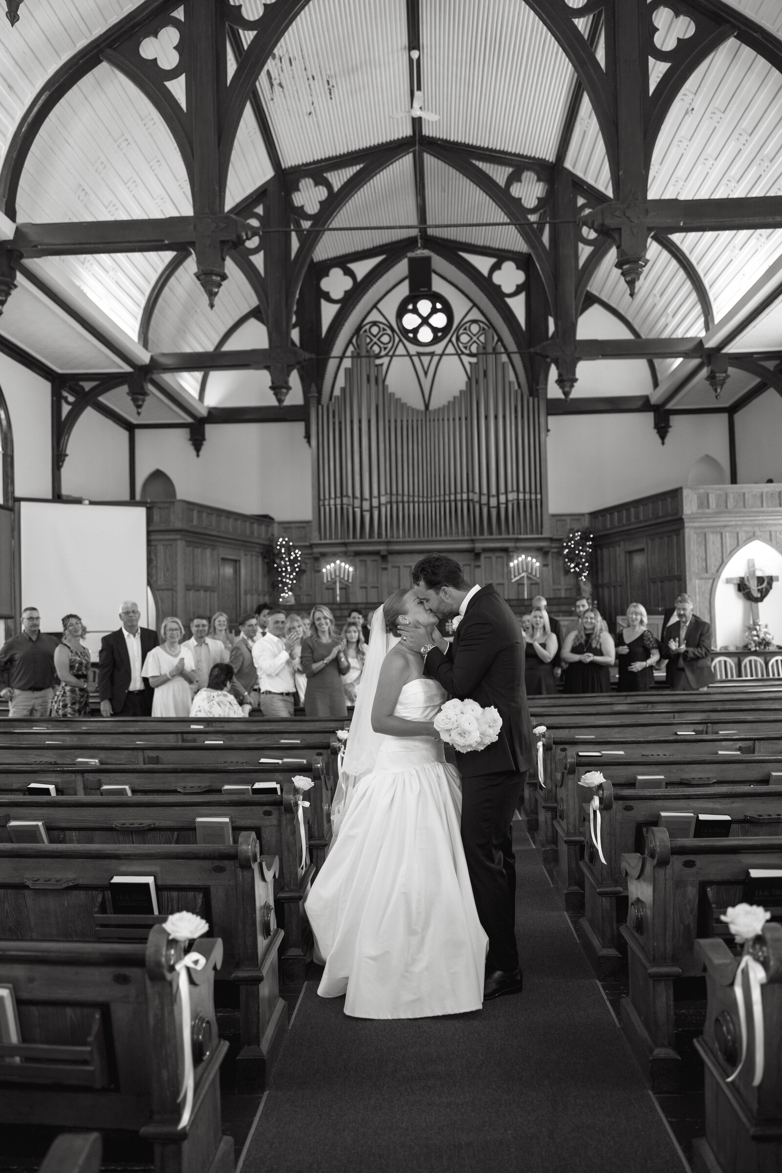 A bride and groom share a kiss on their way back down the aisle after getting married at a church in Liverpool, Nova Scotia. 