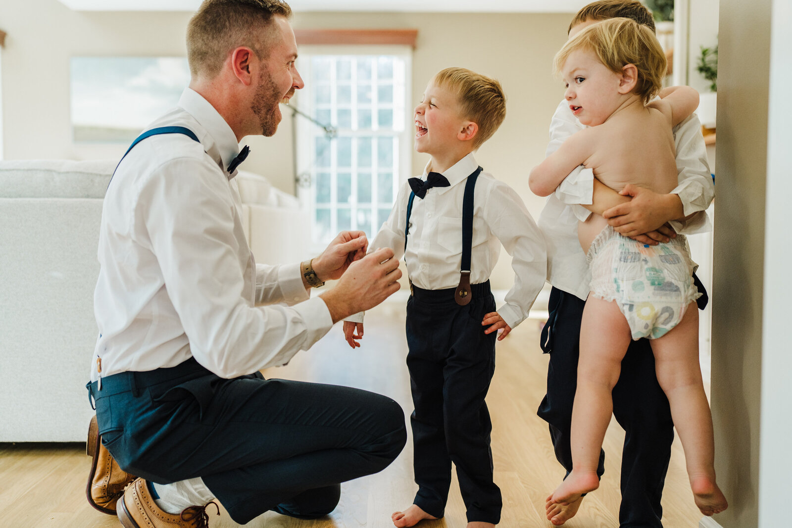 dad gets sons into tuxes for wedding ceremont