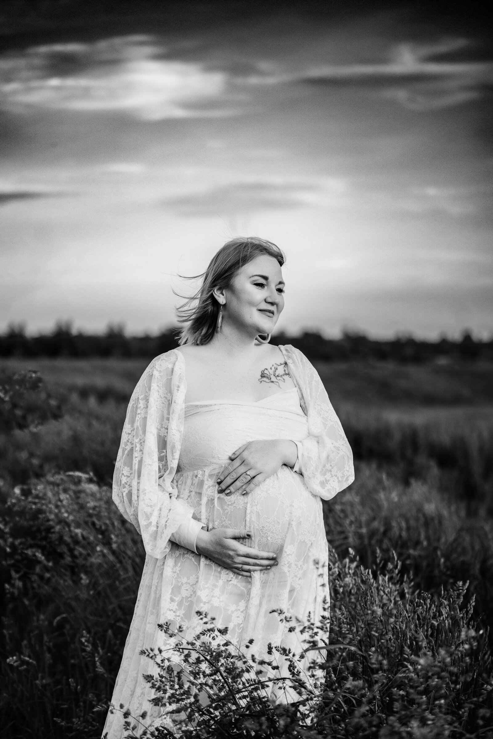 black and white portrait of pregnant woman in field