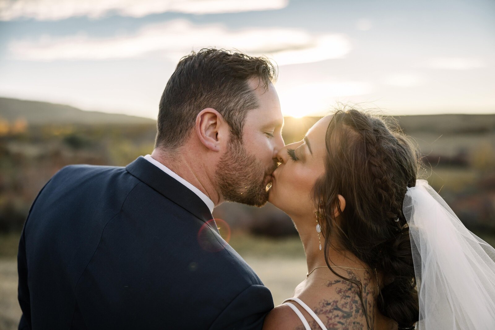 backlit sunset kiss from bride and groom