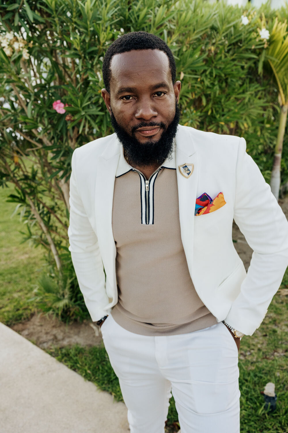 Man in a white suit jacket posing outdoors