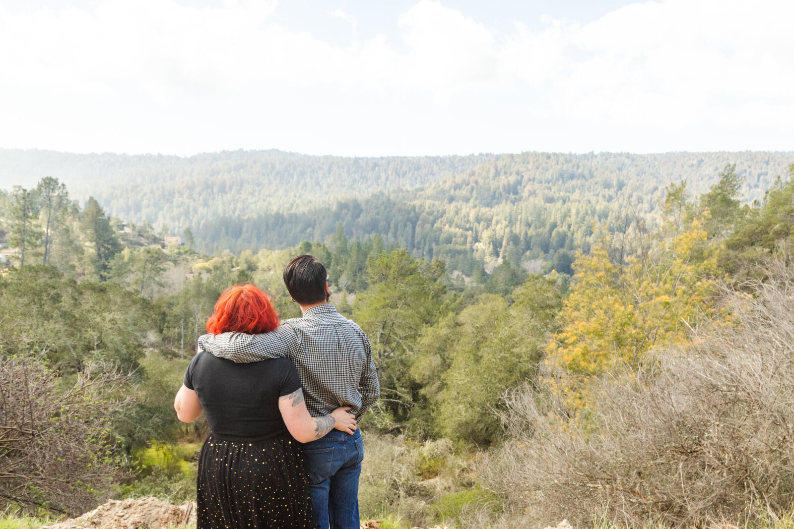 An tattooed engaged couple poses for photos in a redwood forest in Santa Cruz, Ca.