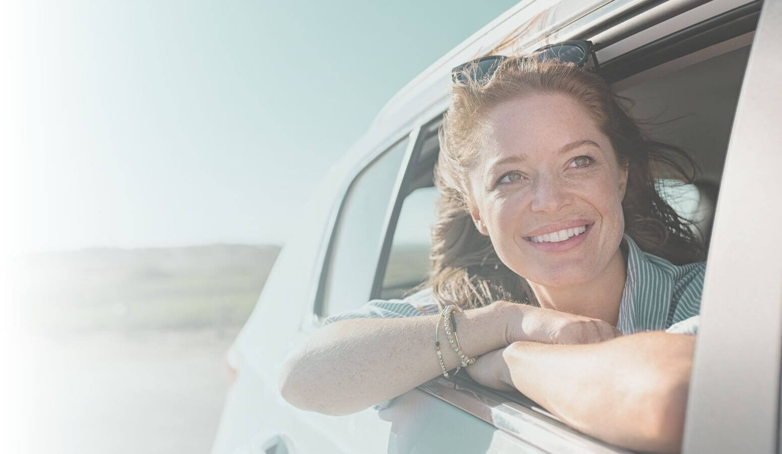 Background smiling woman leaning out of car window