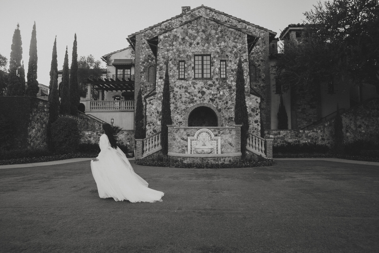 Bride runs though yard in black and white at Bella Collina Wedding Venue Orlando